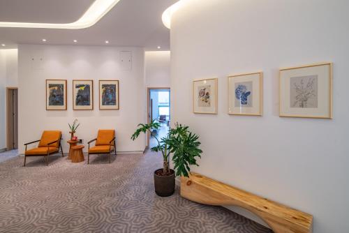 a waiting room with chairs and paintings on the wall at Wuyu Hotel - Chongqing Liangjiang Happiness Plaza & Xingfu Square & GuangdianYuan metro in Chongqing