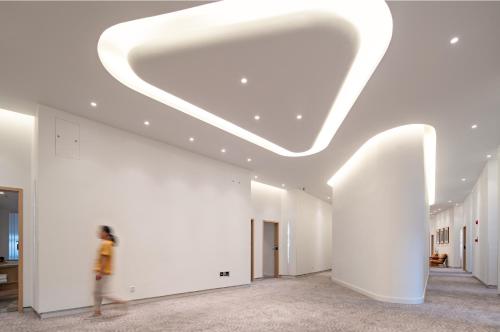a person walking through a large room with a ceiling at Wuyu Hotel - Chongqing Liangjiang Happiness Plaza & Xingfu Square & GuangdianYuan metro in Chongqing