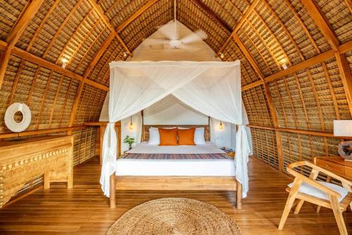 - une chambre avec un lit dans une cabane en paille dans l'établissement Nest Uluwatu 1 - Eco Boutique Villa, à Uluwatu