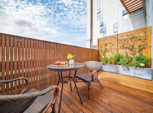 a patio with a table and chairs on a wooden deck at Wuyu Hotel - Chongqing Liangjiang Happiness Plaza & Xingfu Square & GuangdianYuan metro in Chongqing
