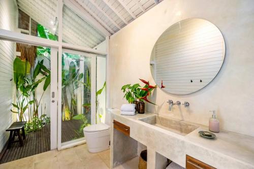 La salle de bains est pourvue d'un lavabo et d'un miroir. dans l'établissement Nest Uluwatu 1 - Eco Boutique Villa, à Uluwatu