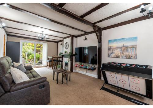 a living room with a couch and a game table at Nature's Serenade:3BR Classic Home-Jacuzzi & Sauna in Canvey Island