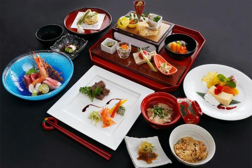 a table with plates of food and bowls of food at Hyakunagaran in Nanjo