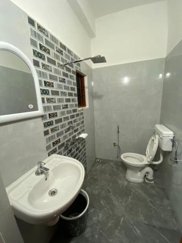 a bathroom with a sink and a toilet at Hotel Abhinov in Dibrugarh