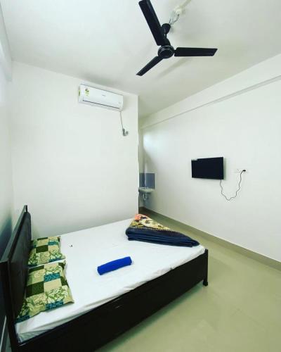 a bedroom with a bed with a ceiling fan at Hotel Abhinov in Dibrugarh