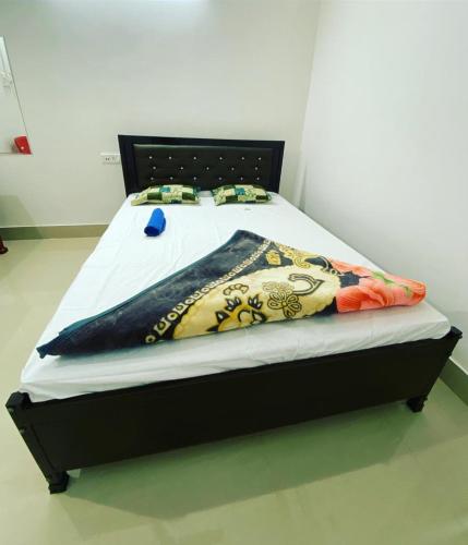 a bed with a black frame with a blanket on it at Hotel Abhinov in Dibrugarh