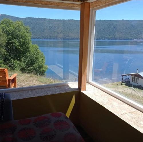 a room with a large window with a view of a lake at Cabañas Icalmahuida in Icalma