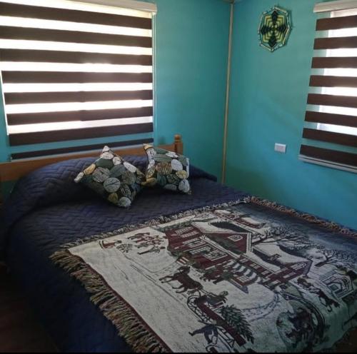 a bedroom with a bed with a blanket with a picture on it at Cabañas Icalmahuida in Icalma