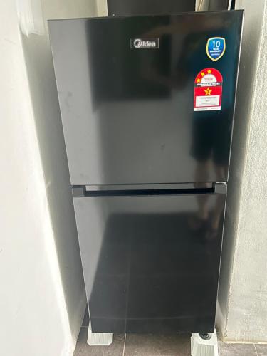 a black refrigerator with a sticker on the door at Roxy Apartment Kuching in Kuching