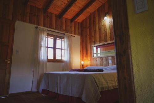 El Camino Suites في فيلا بيرنا: غرفة نوم بسرير ونافذة في غرفة