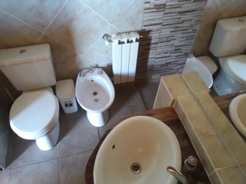 a bathroom with a toilet and a sink at El Camino Suites in Villa Berna
