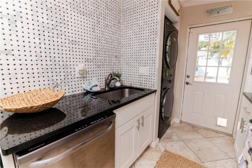 uma cozinha com um lavatório e uma bancada em Happy Camper Cottage - Cozy Oasis with Hot Tub em Palm Harbor