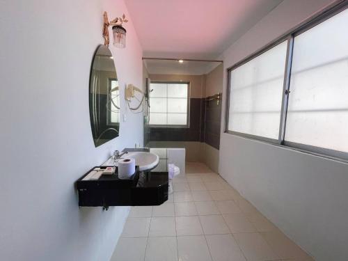 W łazience znajduje się umywalka i lustro. w obiekcie Best Central Point Hotel w mieście Phnom Penh