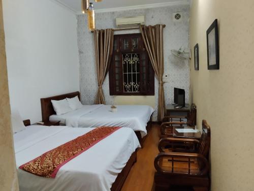 um quarto de hotel com duas camas e uma janela em Holiday Home em Hanói