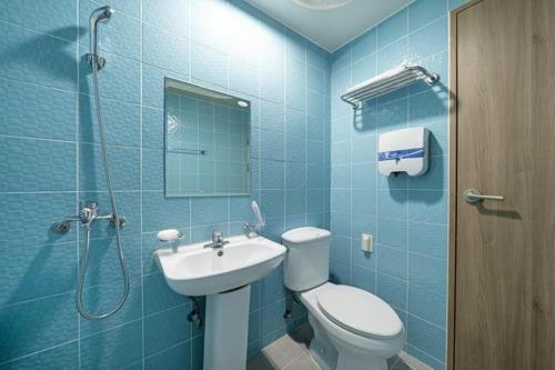 La salle de bains bleue est pourvue de toilettes et d'un lavabo. dans l'établissement Yongmaru Pension, à Suncheon