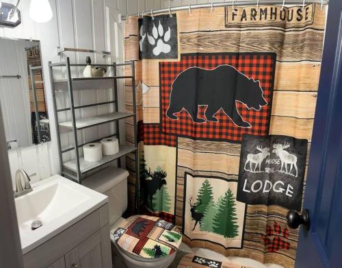 a bathroom with a bear shower curtain in a bathroom at Cozy Indian Lake Chalet on Golf Course with Arcade/Gameroom in Stoystown