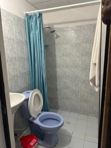 a bathroom with a blue toilet and a sink at Casa Tamarielys in Cartagena de Indias