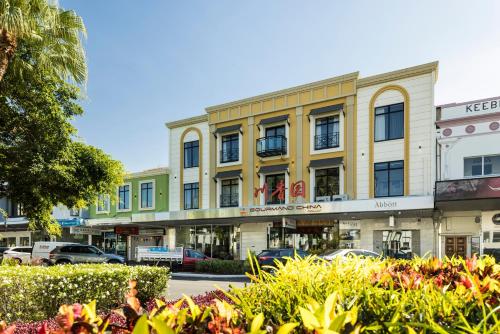 ein Gebäude auf einer Straße mit vor der Tür geparkt in der Unterkunft The Abbott Boutique Hotel in Cairns