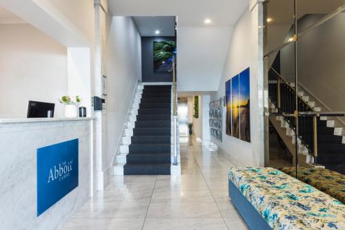 a lobby with a staircase and a couch at The Abbott Boutique Hotel in Cairns