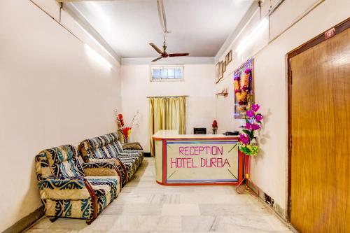 a living room with couches and a table with a sign at SPOT ON Durba 2 in Tezpur