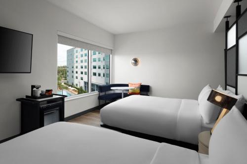 a hotel room with two beds and a window at Aloft Orlando Lake Buena Vista in Orlando