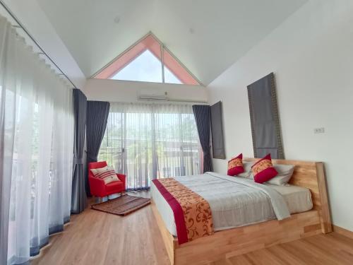 een slaapkamer met een bed en een groot raam bij อัญมัน ลันตา Anyaman Lanta in Koh Lanta