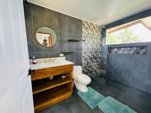 a bathroom with a sink and a toilet and a mirror at Three Soul 3 in Jabillos