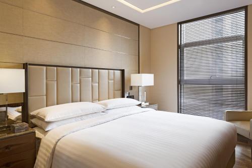 西安的住宿－西安萬豪行政公寓，卧室设有一张白色大床和一扇窗户。