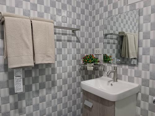 La salle de bains est pourvue d'un lavabo, d'un miroir et de serviettes. dans l'établissement อัญมัน ลันตา Anyaman Lanta, à Ko Lanta