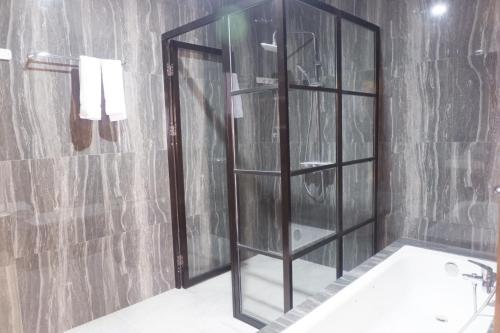 ein Bad mit einer Dusche, einem Spiegel und einem Waschbecken in der Unterkunft Agape Hotel Haranggaol in Haranggaul