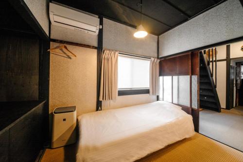 een kleine slaapkamer met een bed en een raam bij HISORI Arts and Stay in Kanazawa