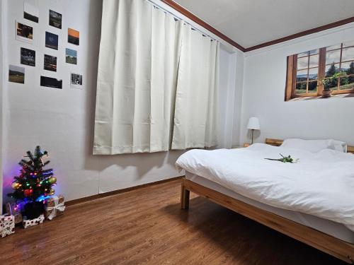 首爾的住宿－Lotus Stay，一间卧室,配有圣诞树和一张床