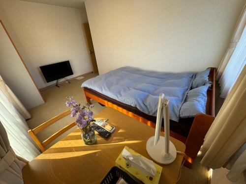 a small room with a bed and a table with a table at South Wind Chalet in Itoshima
