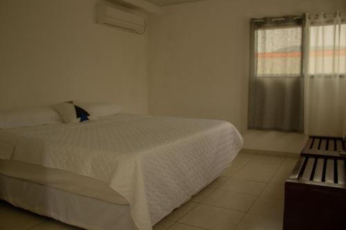 a bedroom with a white bed and a window at Portofino in Playa San Blas