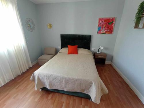 a bedroom with a bed with a red pillow on it at Like/Home in Lima