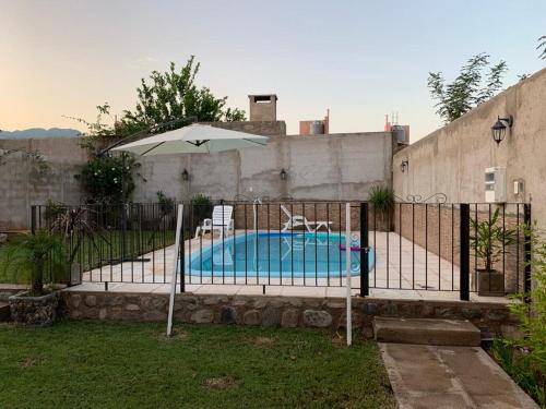 a pool with an umbrella and two chairs and a table at Hermosa casa con piscina . in La Rioja