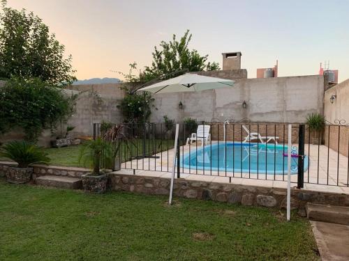 a pool with an umbrella and two chairs at Hermosa casa con piscina . in La Rioja