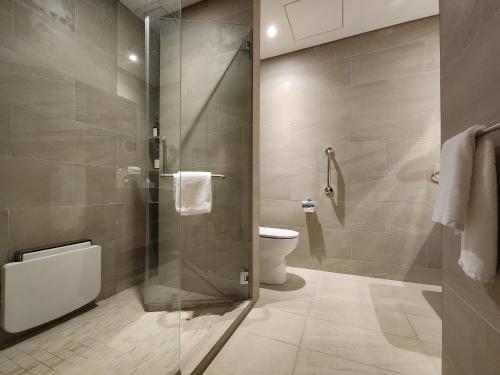 a bathroom with a toilet and a glass shower at Domitys Bangsar Kuala Lumpur in Kuala Lumpur