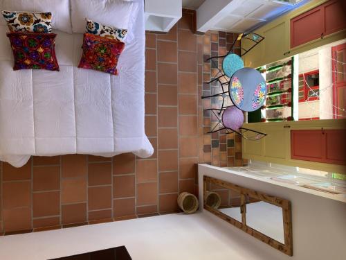 La salle de bains est pourvue d'un miroir et d'oreillers sur un mur. dans l'établissement La Puerta, à Duitama