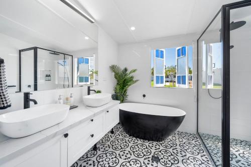 a bathroom with two sinks and a large tub at Elegant 3-Bed 2-Bath Cottage: Classic Charm with a Modern Twist in Townsville