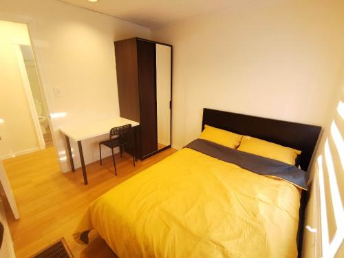 - une chambre avec un lit jaune et un bureau dans l'établissement Lucky-luck46, à Markham