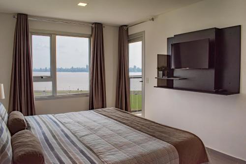 a bedroom with a bed and a flat screen tv at Parana Playa 1103 in Encarnación