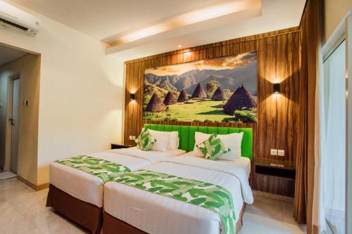 a bedroom with a bed with a painting on the wall at Sylvia Hotel & Resort Komodo in Labuan Bajo