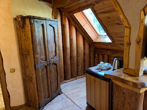 a kitchen with a large wooden door in a cabin at Zatin in Yaremche