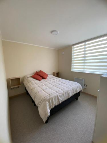 a bedroom with a bed with red pillows on it at Arriendo departamento villarrica in Villarrica