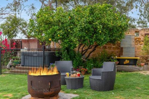 a fire pit in a yard with chairs and a tree at 'Bella Vista' in Mannum