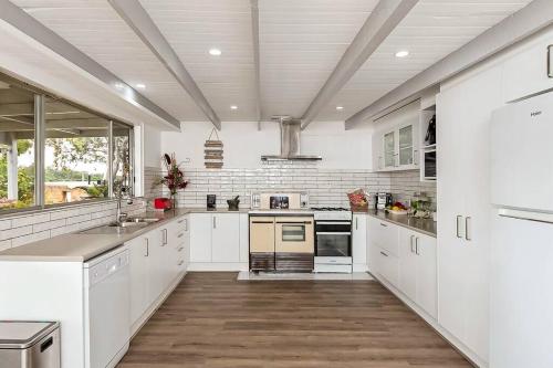 a large kitchen with white cabinets and white appliances at 'Bella Vista' in Mannum