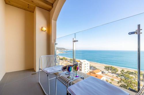 a balcony with a table and chairs and a view of the ocean at Hound Hotel Ulsan in Ulsan