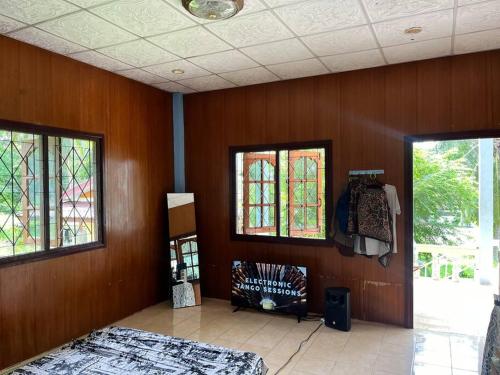 a room with wooden walls and stained glass windows at Lee’ s Chill House in Srithanu