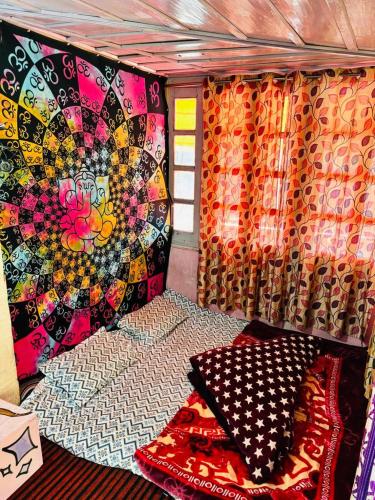 Ce lit se trouve dans une chambre dotée d'un mur coloré. dans l'établissement Trishul Cafe, à Tosh